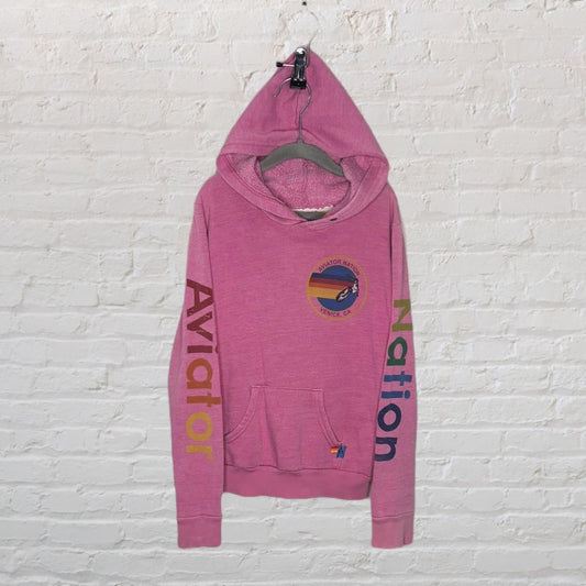 Pink Aviator Nation hoodie with colorful sleeve text and logo on the chest, featuring a retro design.