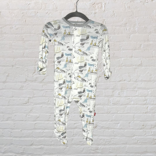 White baby onesie with nautical-themed prints in various colors, featuring footed design, hanging on a hanger.