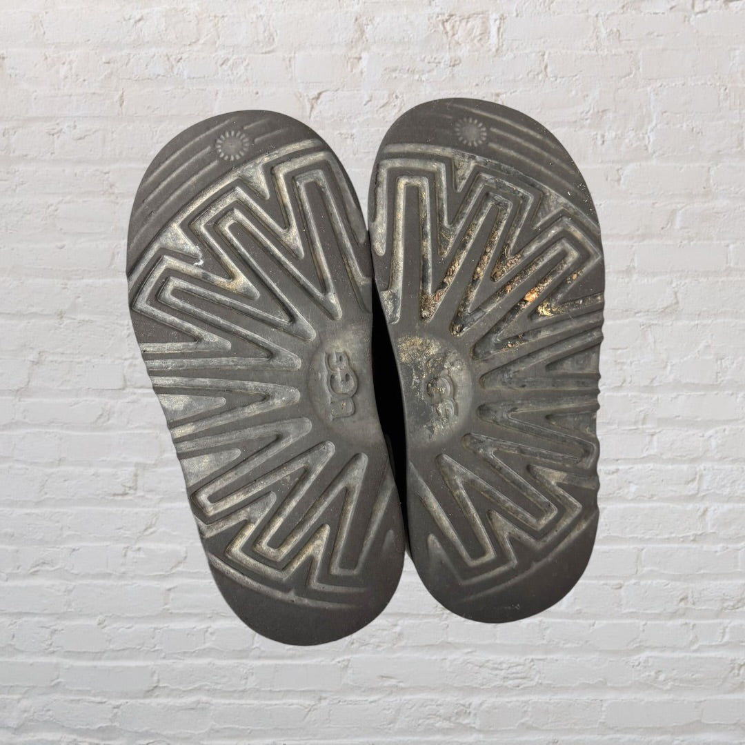 Pair of UGG short rubber boots in black with UGG logo on the side.