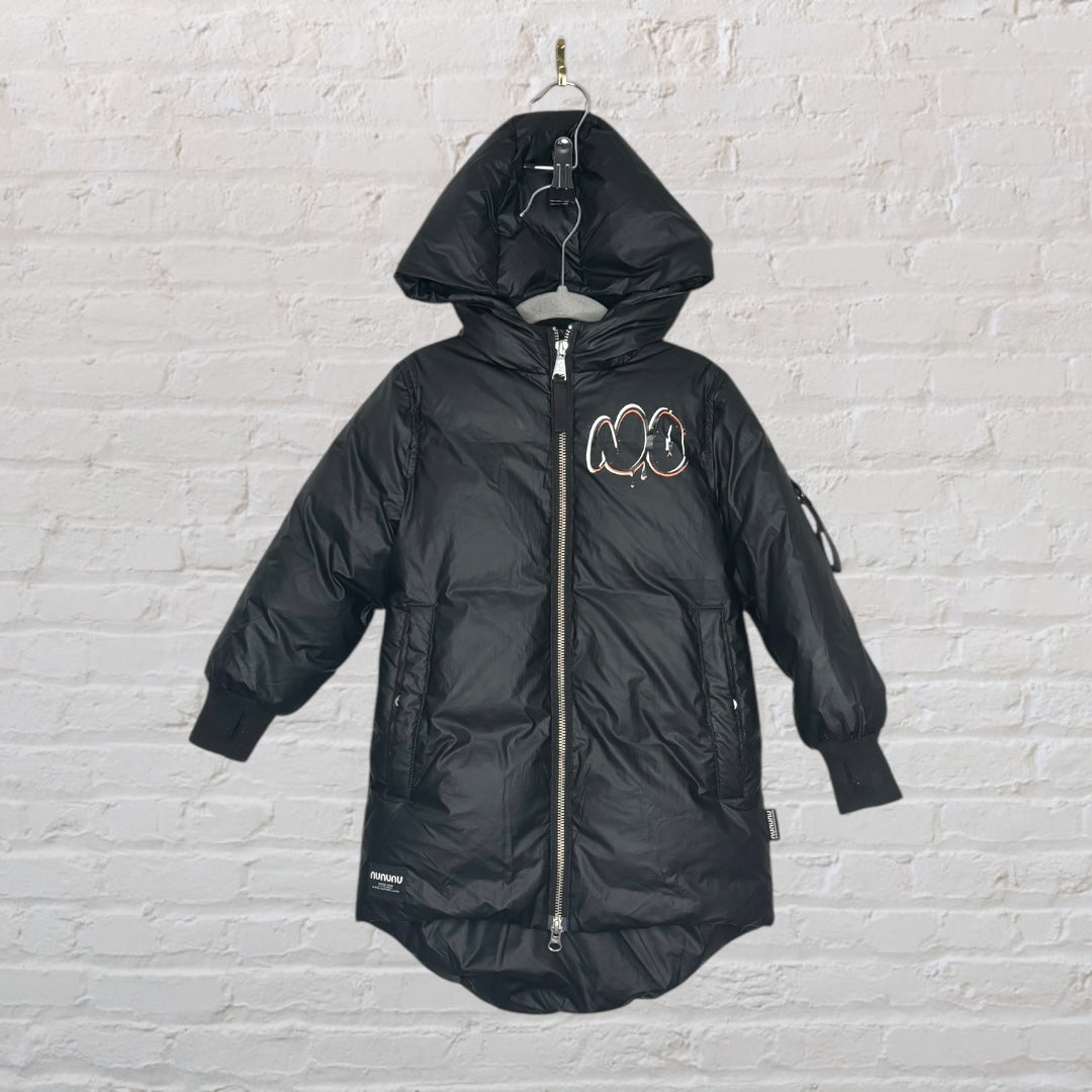 Black hooded puffer jacket featuring a large pink skull graphic on the back, hung against a brick wall background.