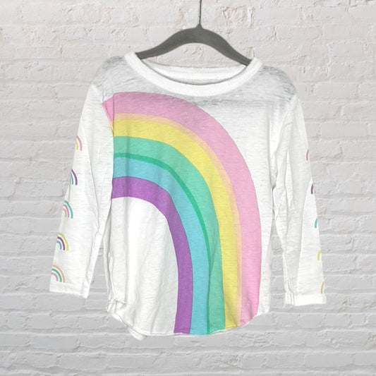 White long sleeve tee with a large colorful rainbow graphic on the front, hanging on a black hanger.