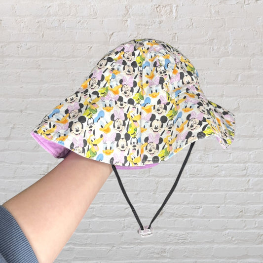 Multicolor bucket hat with Disney characters print, featuring an adjustable chin strap.