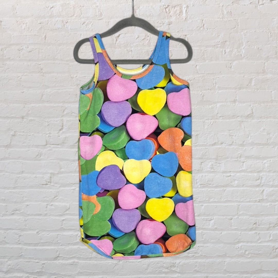 Sleeveless tank dress with a vibrant multicolour heart candy print hanging on a hanger.