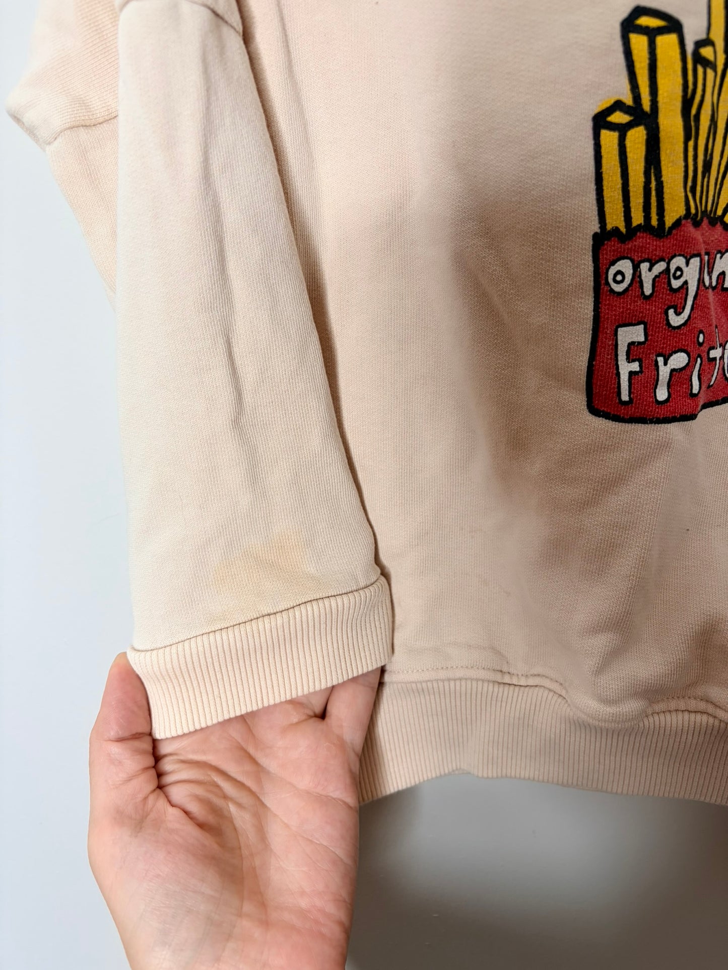 Beige sweatshirt with 'Pommes Frites' text and a graphic of fries in a red carton labeled 'organic frites'.