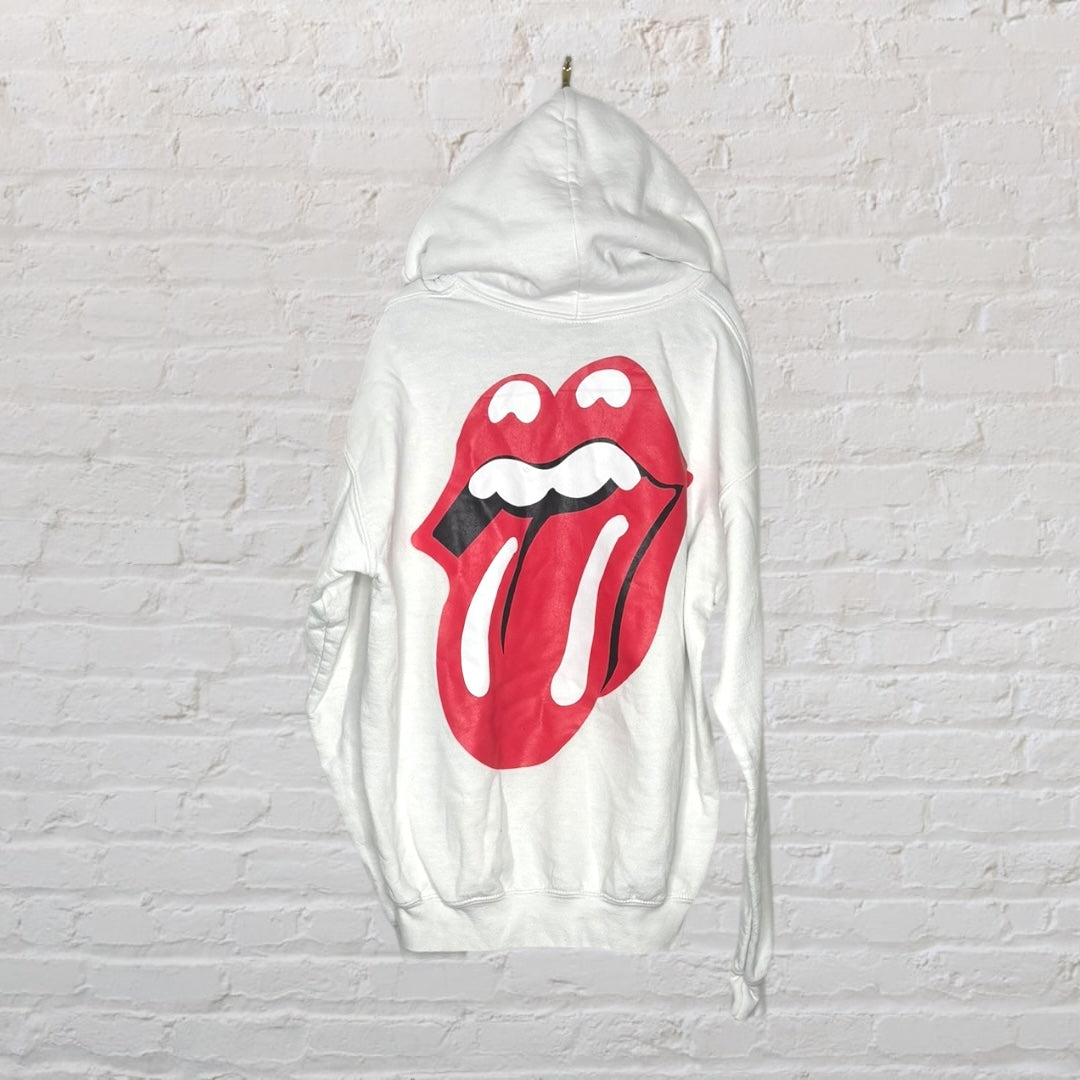 White hoodie featuring a large red tongue graphic on the back, displayed against a white brick wall.