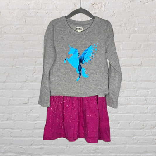 Gray long-sleeve dress with blue unicorn print and pink sparkle skirt, by Hatley, hanging on a black hanger.