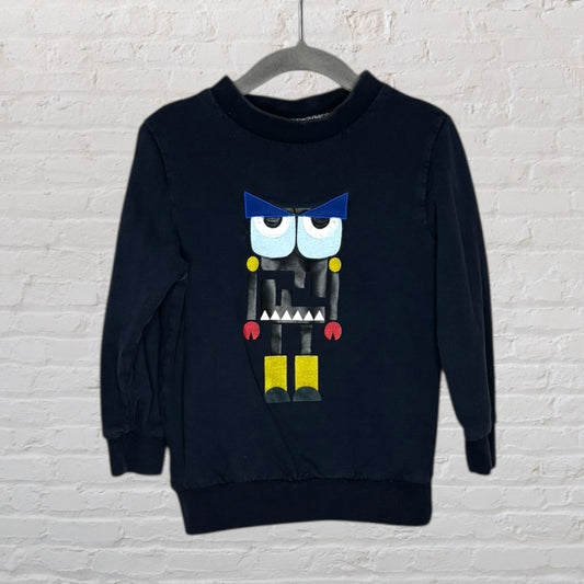 Black long-sleeve sweatshirt featuring a colourful monster graphic with blue, yellow, and red accents, hanging on a hanger.