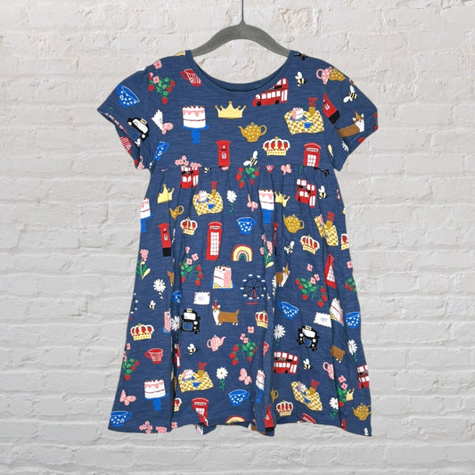 A blue A-line dress with colorful British-themed print, including crowns, buses, and flowers.