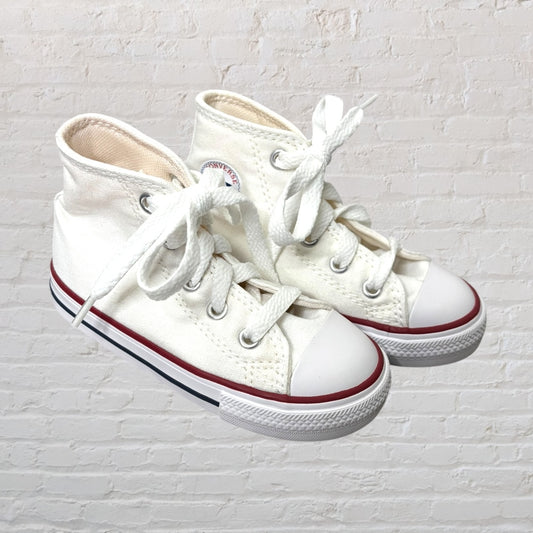 Pair of classic high-top white canvas sneakers with rubber soles and red stripe detailing.