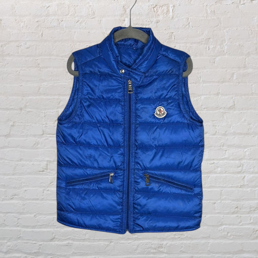 Blue Moncler quilted puffer vest with front zipper and brand logo, displayed on a hanger.