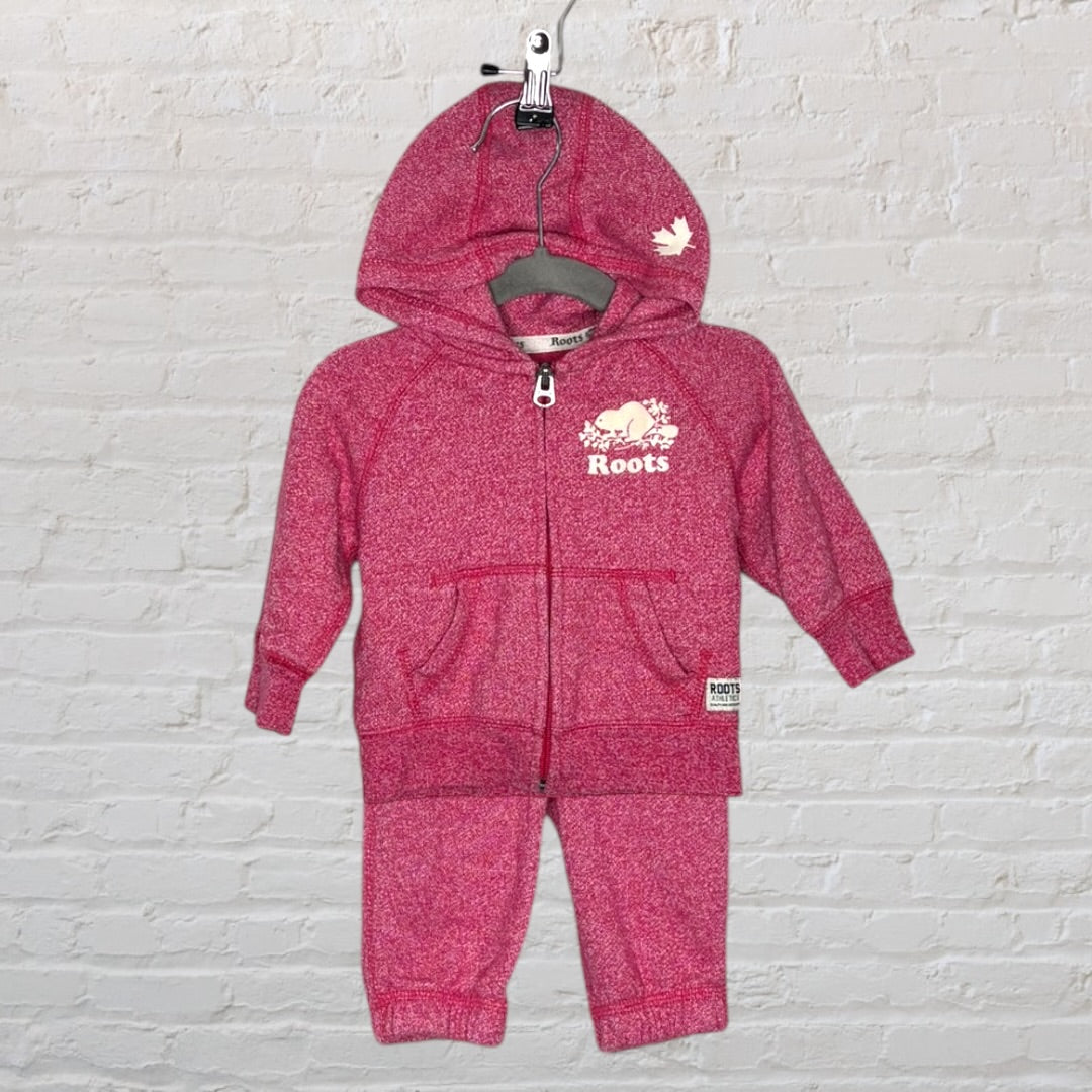 Pink toddler tracksuit set by Roots with hoodie and pants, featuring logo and maple leaf design.