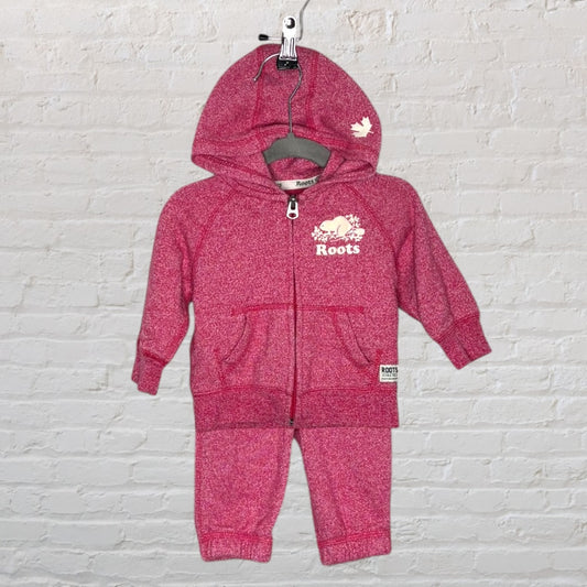 Pink toddler tracksuit set by Roots with hoodie and pants, featuring logo and maple leaf design.