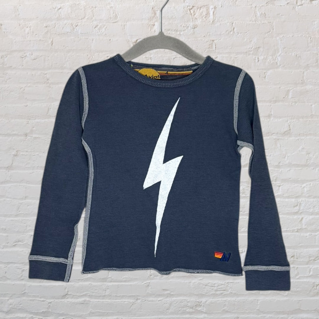 Navy blue long sleeve t-shirt with white lightning bolt graphic and contrasting stitching, displayed on a hanger.