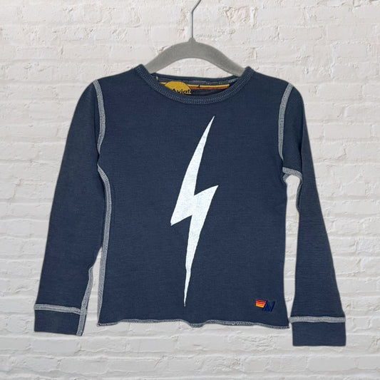 Navy blue long sleeve t-shirt with white lightning bolt graphic and contrasting stitching, displayed on a hanger.