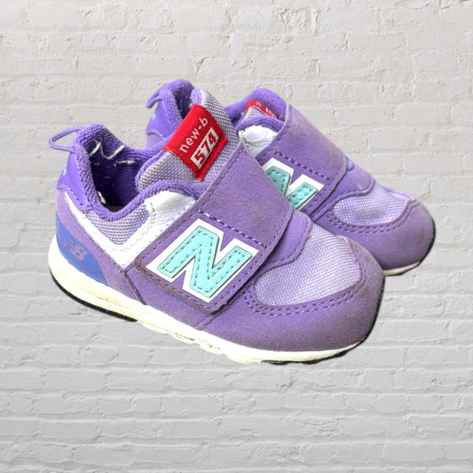 Purple New Balance 574 kids sneakers with aqua logo and Velcro straps.