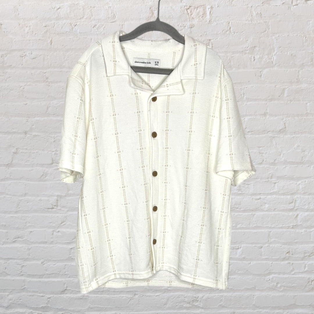 Off-white short sleeve button-up shirt with textured pattern, displayed on a hanger.