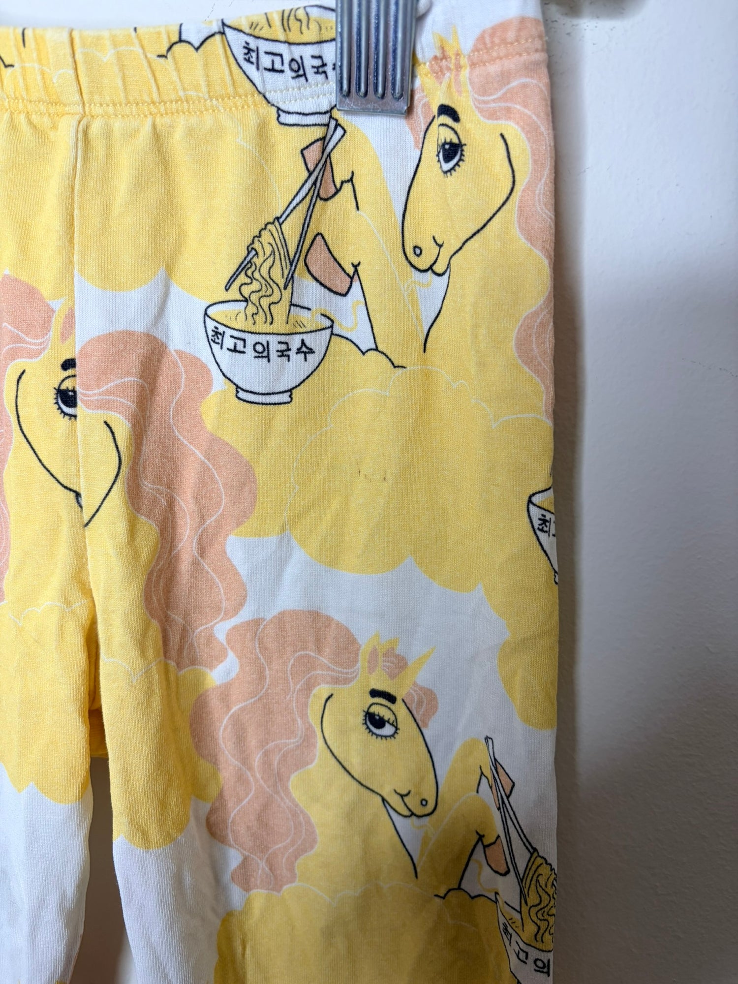 Multicoloured kids sleepwear set with various graphic designs including mermaids, cacti, and whimsical creatures.
