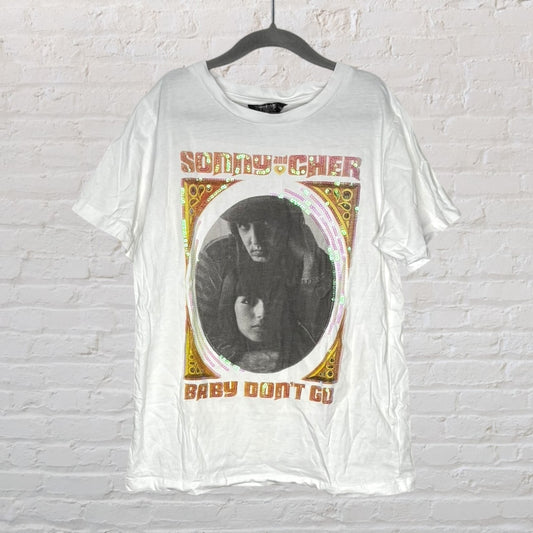 White T-shirt featuring a Sonny and Cher graphic with 'Baby Don't Go' text and decorative border, hanging on a hanger.