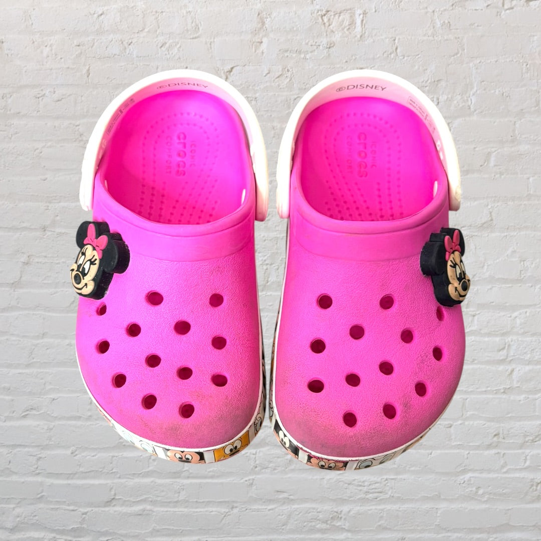 Pink Crocs clogs with Minnie Mouse design and Disney character print on the sole, featuring adjustable heel strap.