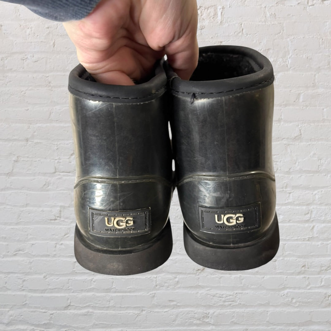 Pair of UGG short rubber boots in black with UGG logo on the side.