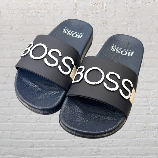 Navy slide sandals with 'BOSS' logo in white embossed across the straps.