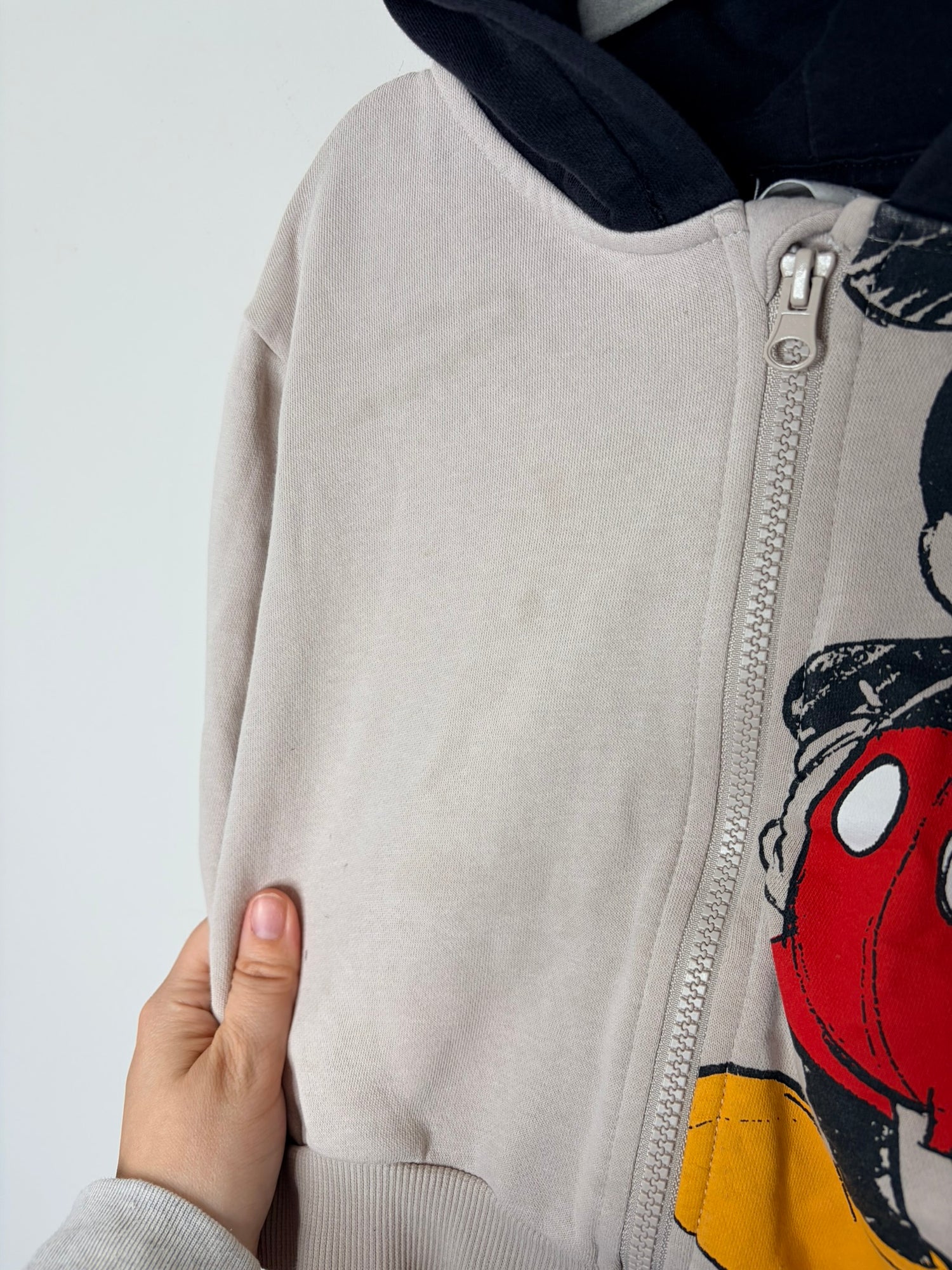 Beige zip-up hoodie with Mickey Mouse graphic and black hood with ears.