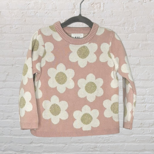Pink knit sweater with large white and gold floral pattern by Hux, displayed on a hanger.