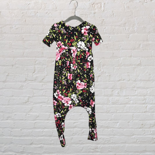 A black floral jumpsuit with pink and white flowers and green leaves, hanging on a hanger.